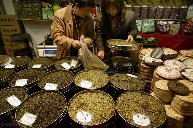 Two Tea Enthusiasts Are Examining The Tea Leaves